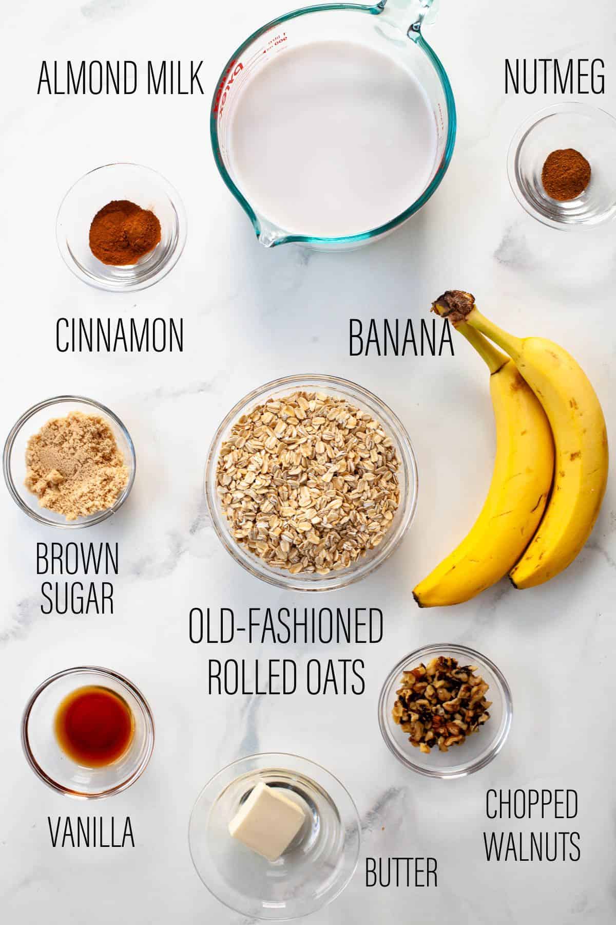 banana bread oatmeal recipe ingredients in bowls over white marble background